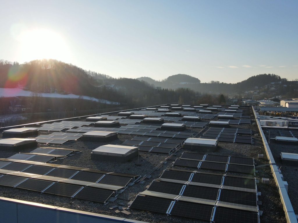 Photovoltaikanlage auf Firmendach bei Sonnenaufgang nachhaltige Stromversorgung strompreise